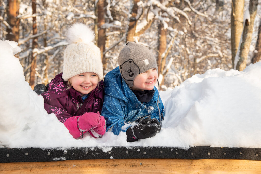 Kaksi lasta lumihangessa iloisena