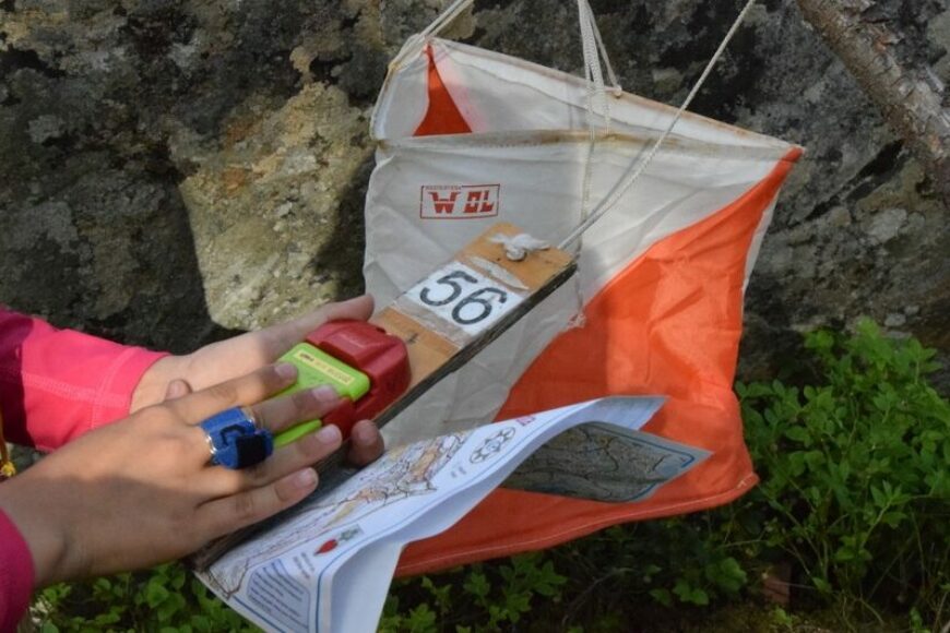 Suunnistaja leimaa itsensä rastilla.