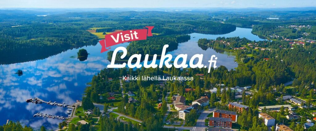 Visit Laukaa mainos. Ilmakuva kirkonkylästä taustalla.